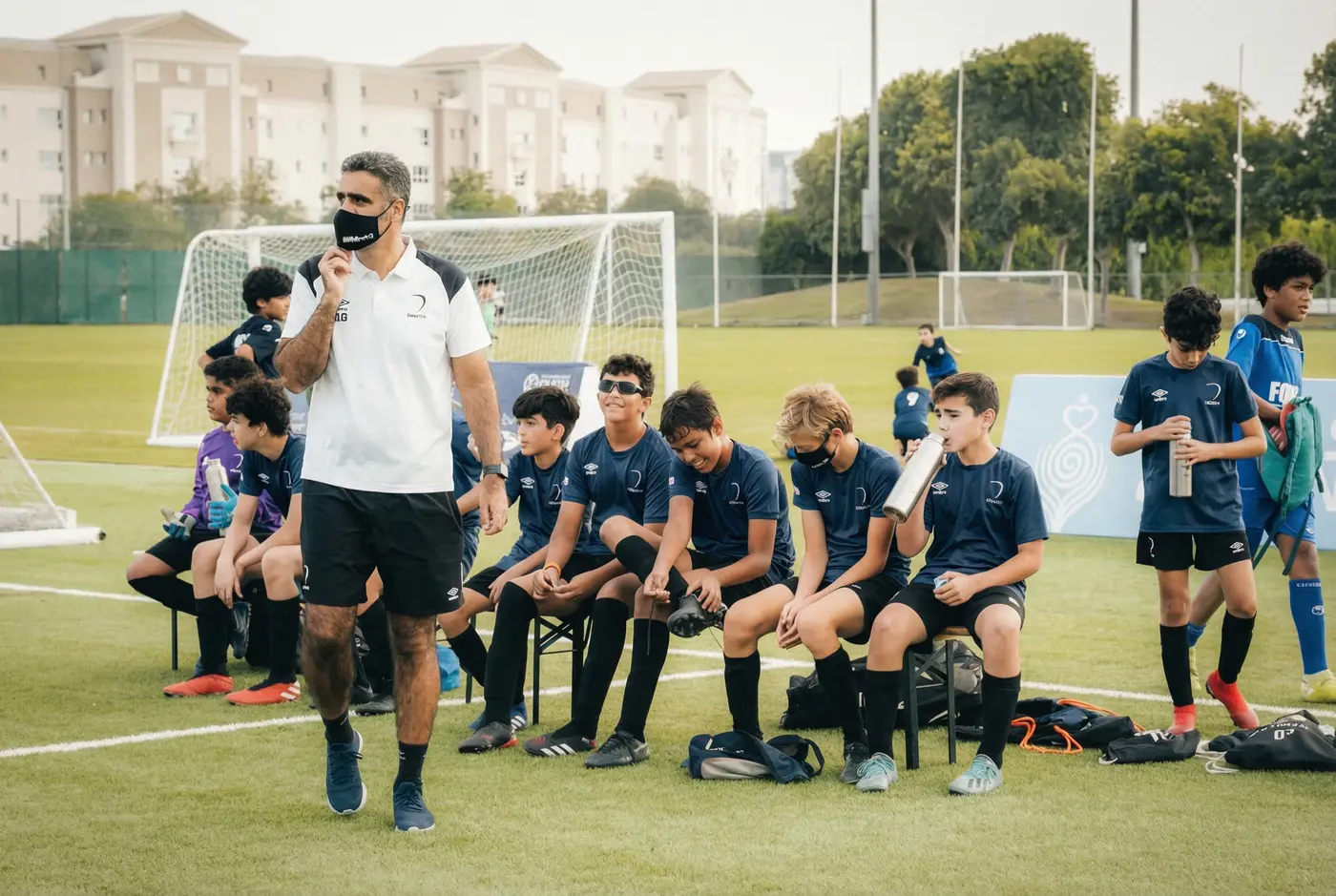 Coach sportif encadrant son équipe lors d'un entraînement sur le terrain
